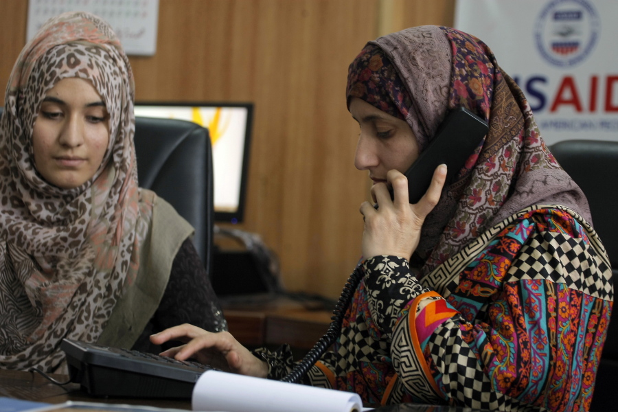 Pakistani lawyer Shandana Naeem, right, listens to a caller with her colleague Nayab Hassan at their office Thursday in Peshawar, Pakistan.