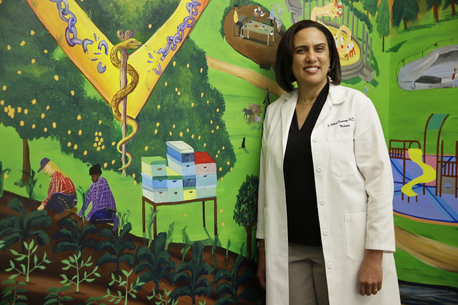Dr. Kirsten Bibbins-Domingo poses by a mural April 7 in the lobby of her office in San Francisco. Draft recommendations from the US Preventive Services Task Force ditch the old advice against PSA screening and say whether to get tested should be left up to men aged 55 to 69 after being informed of the potential benefits and harms. The advice would bring the influential panel more in line with other major doctor groups.