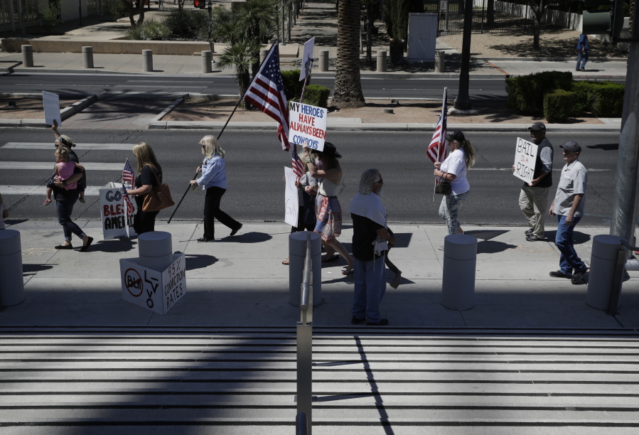 People march in support of defendants on trial in federal court Wednesday in Las Vegas. A federal jury in Las Vegas heard closing arguments in the trial of six men accused of wielding weapons to stop federal agents from rounding up cattle near Nevada rancher Cliven Bundy&#039;s property in 2014.