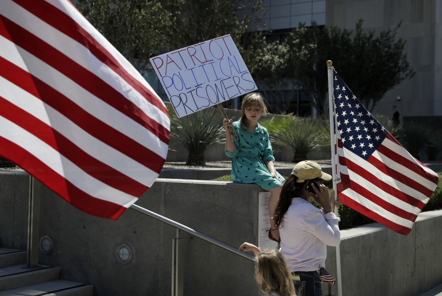 Nine-year-old Paylynn Lawrimore holds up a sign in support of defendants on trial in federal court Wednesday in Las Vegas. A federal jury in Las Vegas heard closing arguments in the trial of six men accused of wielding weapons to stop federal agents from rounding up cattle near Nevada rancher Cliven Bundy&#039;s property in 2014.