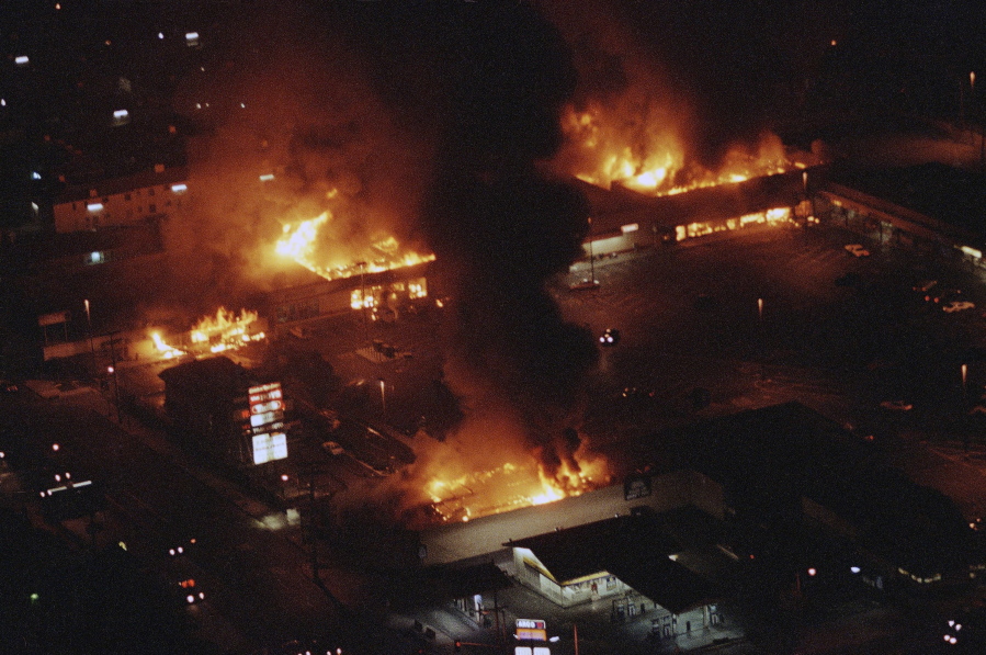 Buildings in a shopping center are engulfed in flames before firefighters arrive during rioting on April 30, 1992, in South-Central Los Angeles.