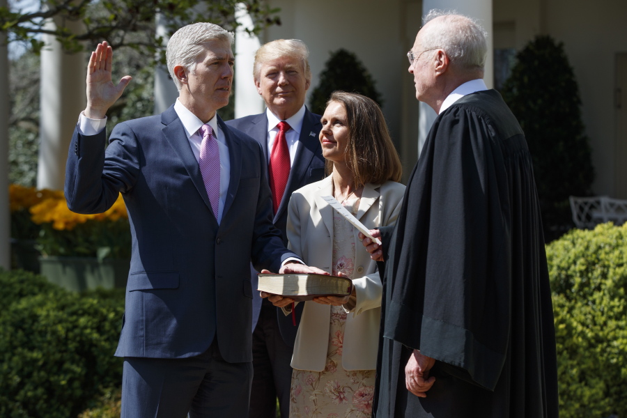 President Donald Trump watches April 10 as Supreme Court Justice Anthony Kennedy administers the judicial oath to Judge Neil Gorsuch during a re-enactment in the Rose Garden of the White House, in Washington. Gorsuch&#039;s wife Marie Louise Gorsuch hold a bible. Republicans have put President Donald Trump&#039;s Supreme Court nominee on the bench, and they&#039;re now in a position to fill dozens more federal judgeships and reshape some of the nation&#039;s highest courts.