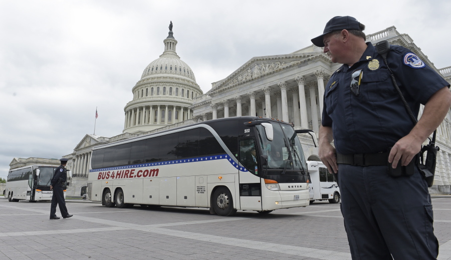 Capitol Hill Police officers stand guard as buses with Senators aboard depart Capitol Hill in Washington, Wednesday, April 26, 2017, headed to the White House to get a briefing on North Korea.