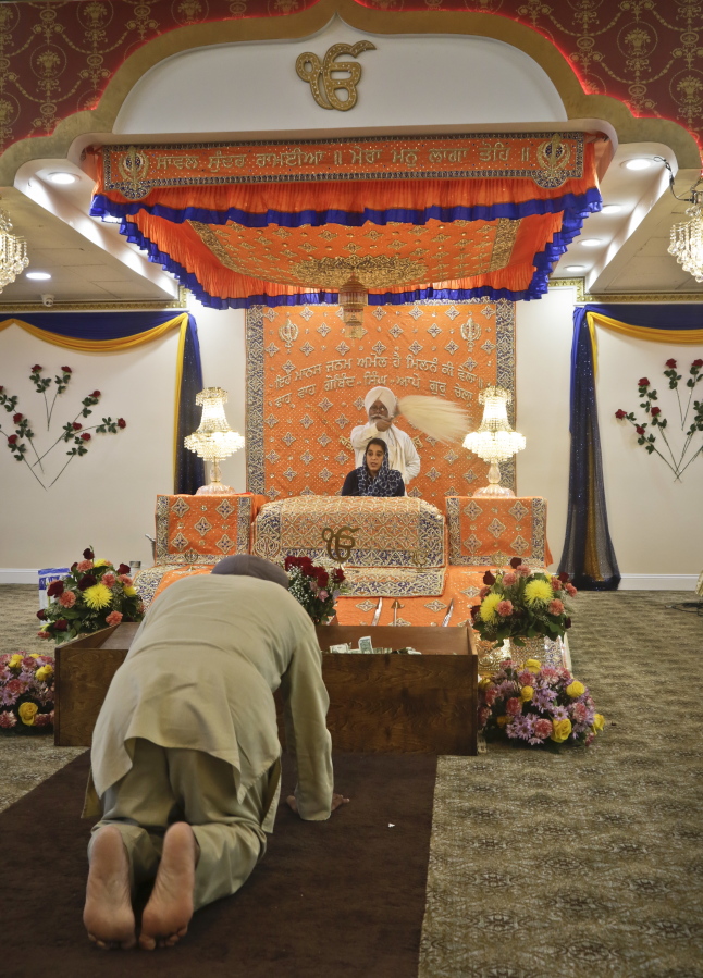 In this April 9, 2017 photo, a Sikh man bows as Satinder Kaur leads a prayer recital at the Guru Nanak Darbar house of worship, in Hicksville, N.Y. Women and men share equal roles in the temple where Sikhs come together for worship and to serve community meals free for anyone regardless of faith, religion or background.