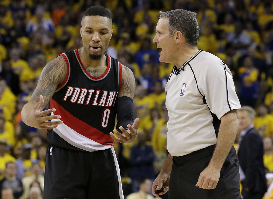 Portland Trail Blazers guard Damian Lillard (0) talks with referee Monty McCutchen during the second half of Game 1 of a first-round NBA basketball playoff series between the Golden State Warriors and the Trail Blazers in Oakland, Calif., Sunday, April 16, 2017. The Warriors won 121-109.