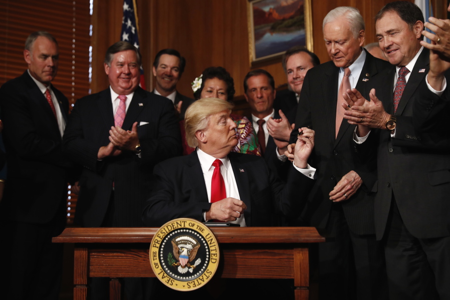 President Donald Trump hands a pen to Sen. Orrin Hatch, R-Utah after signing an Antiquities Executive Order during a ceremony at the Interior Department in Washington, Wednesday.