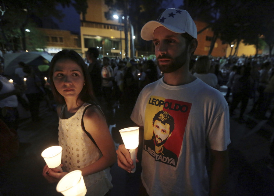 A student wearing a T-shirt with an image of jailed opposition leader Leopoldo Lopez attends a candlelight vigil for classmate Juan Pablo Pernalete in Caracas, Venezuela, Saturday, April 29, 2017. Students commemorated Pernalete who was killed this week by security forces during an anti-government protest.