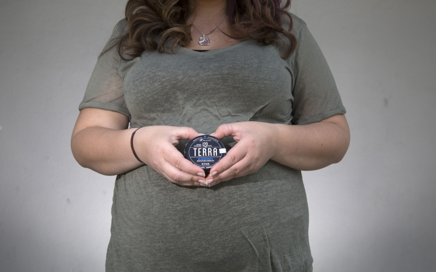 Richelle, of San Jose, holds a can of chocolate-covered blueberries infused with cannabis in San Jose, Calif., on April 19. Richelle is 24 weeks pregnant and a marijuana user, using it to alleviate her nausea.