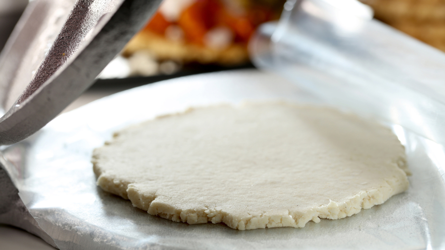 Gorditas are masa dough disks, a good deal thicker than a tortilla. You can flatten them in a tortilla press, leaving them about 1/4- to 1/8-inch thick. Food styling by Mark Graham.