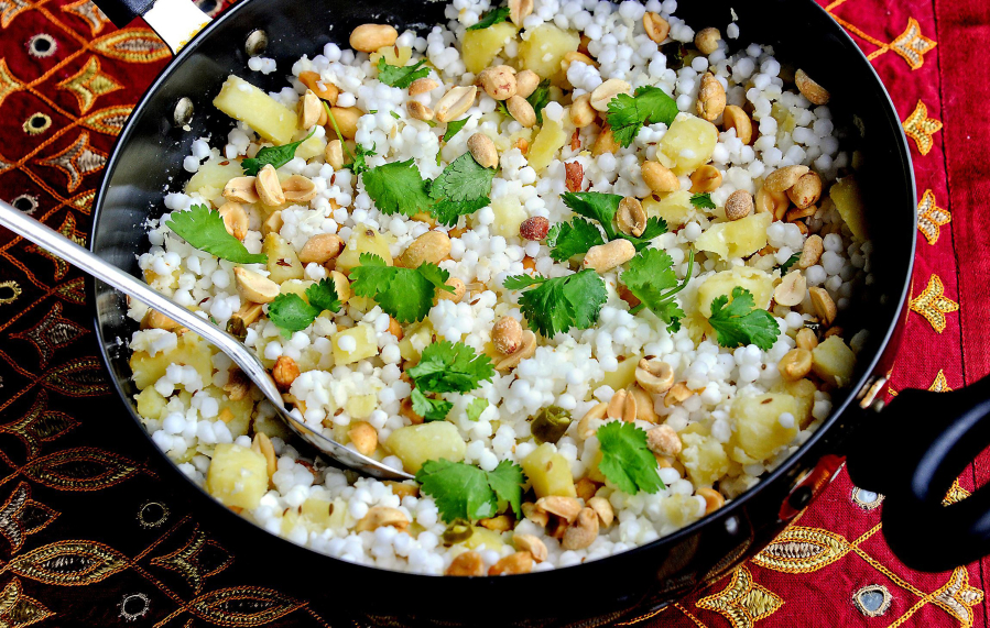 Sabudana khichdi is made with tapioca pearls, cubed potatoes, peanuts, green chilies and lime juice, garnished with cilantro.