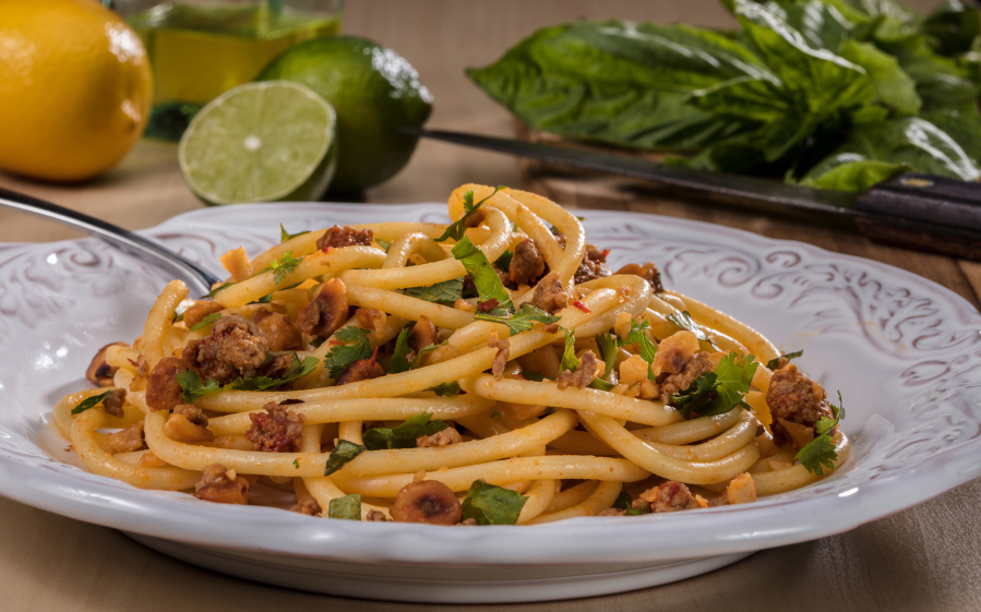 Bucatini, a long, spaghetti-like noodle with a hole running through the length of it, is tossed with hazelnuts, red pepper paste, lamb and fresh herbs.