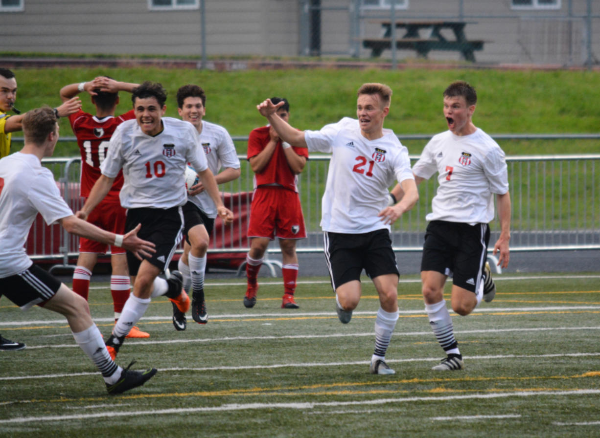 Camas High School's Josh Tkachenko (21) celebrates after scoring the game-winning goal in overtime against Sunnyside on Wednesday at Doc Harris Stadium. Toby Pizot (10) and Erik Brainard (7) are also pictured.