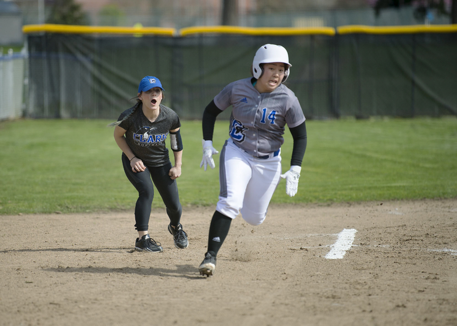 Clark freshman Karley Yoshioka, rounding the bases past head coach Meghan Crouse, went 5 for 7 with three RBI and four runs scored on the first day of the NWAC Softball Championships in Spokane on Friday, May 19, 2017.