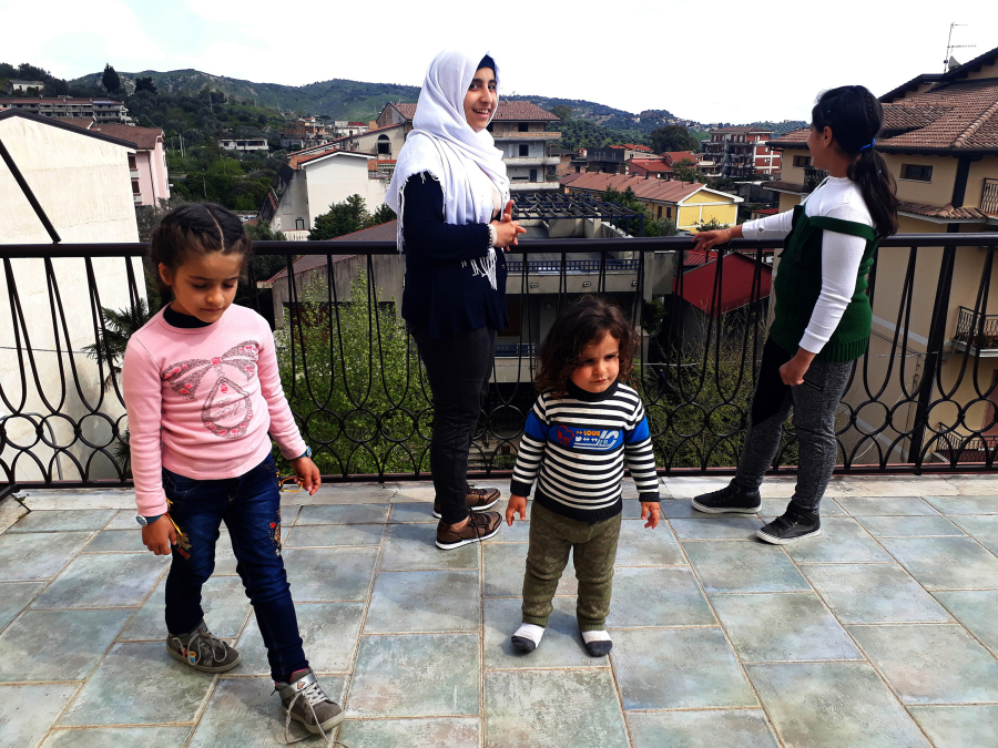 From left, Ghima, 7; Mais, 15; Bader, 2; and Ghazal, 14, stand on the rooftop terrace in their family’s new home in the southern Italian town of Gioiosa Ionica. The children and their parents, Mohammed Ali and Kinda Nonoo, fled the war-torn Syrian city of Aleppo.