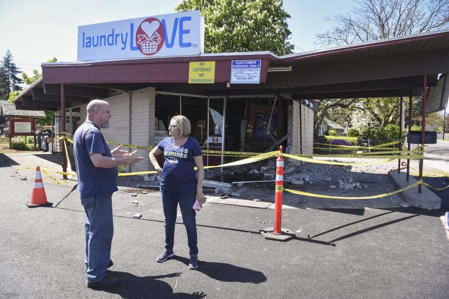 Vancouver resident Kevin Stanfield, left, talks to the manager of Laundry Love, Jackie James, about the damage caused by a Dodge Charger crashing into the front of the building. James heard about the incident soon after it happened.