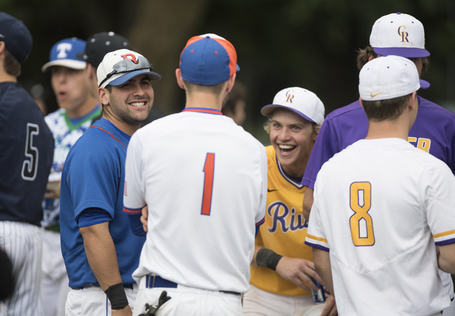 Ridgefieldís Kevin Miser (10), left, laughs with Ridgefieldís Shane Davis (1) and Columbia Riverís Brian Rice (2) during a break at the 40th annual Southwest Washington senior all-star baseball game at Propstra Stadium Wednesday, May 31, 2017.