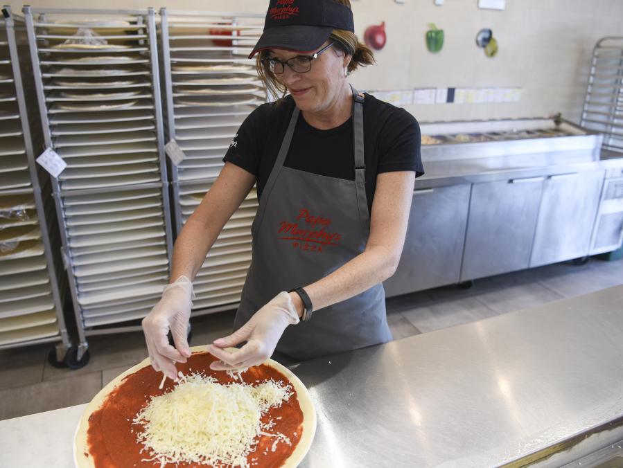 Jean Birch, chairwoman and interim CEO of Papa Murphy’s, makes a pizza at a Vancouver store during a recent executive visit to franchisees. Birch is hoping to rebuild relationships after a tumultuous stretch.