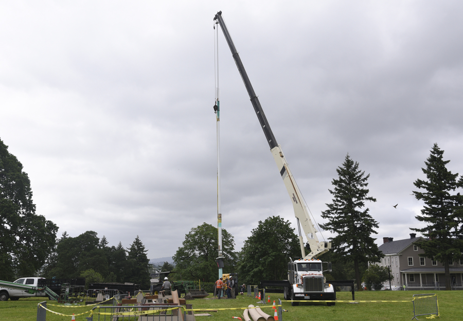 A crane hoists the new flagpole into position Thursday morning at Fort Vancouver National Historic Site.