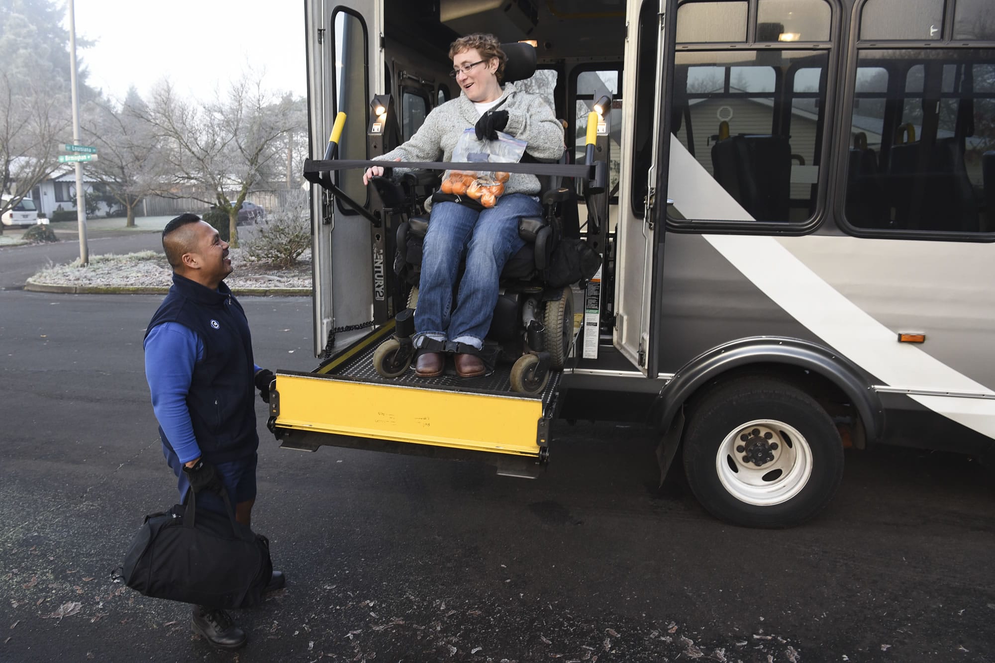 C-Van driver Jaime Somosot helps Kristine Graham into the C-Van bus before driving her to Clark College in December.