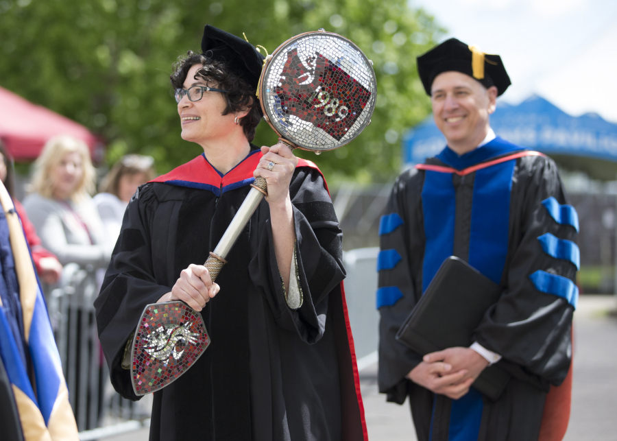 Elizabeth Soliday, left, associate professor of human development, carries in Washington State University Vancouver&#039;s ceremonial mace during Saturday&#039;s commencement with Chancellor Mel Netzhammer, right. (Randy L.