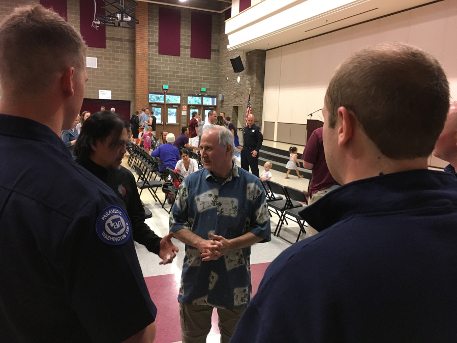 Roland Dizon, left, and George Tierney talk Thursday with the paramedics who helped save Tierney’s life last month. All were at Chief Umtuch Middle School in Battle Ground to honor the first aid efforts of Dizon and others, all other members of Tierney’s community basketball team.