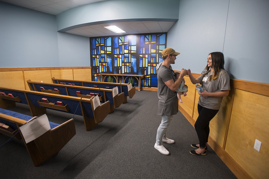Jordan Shaw, lead youth pastor at Faith Center Church, holds baby Hazel Shaw, 2 months, as he encourages Daybreak outpatient client Taylor Ledesma, 18, during a tour of the Daybreak Youth Services RWC Center for Adolescent Recovery in Brush Prairie.