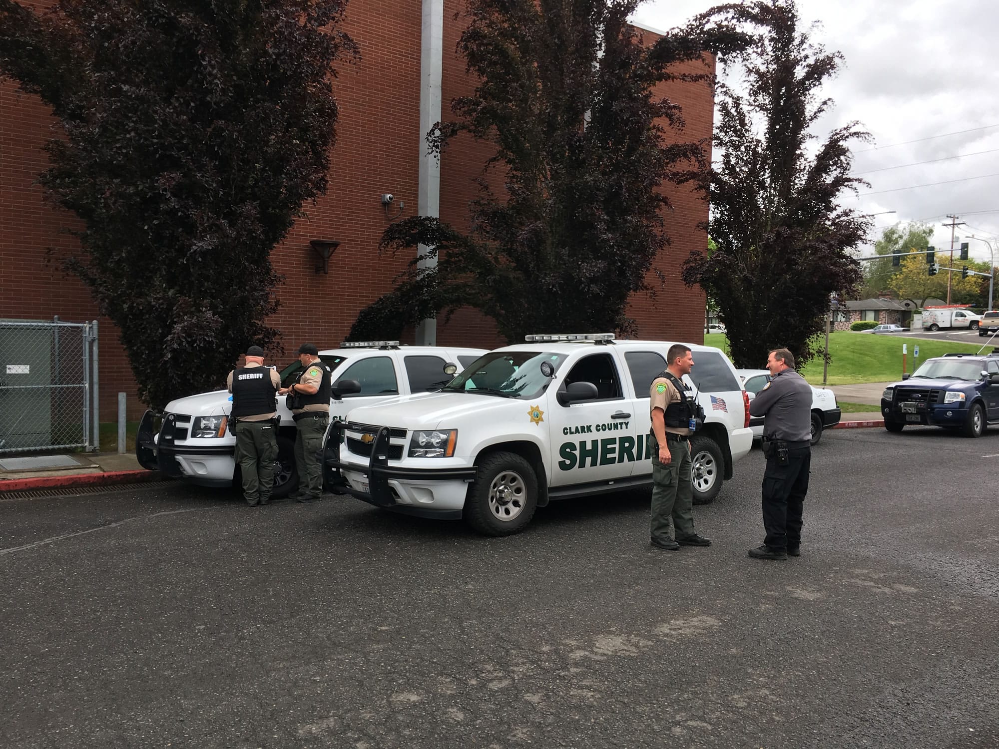 School district and Clark County Sheriff's Office personnel gather outside of Columbia River High school after detaining a transient man who walked inside the school unauthorized Wednesday morning, prompting a short lockdown at the school.