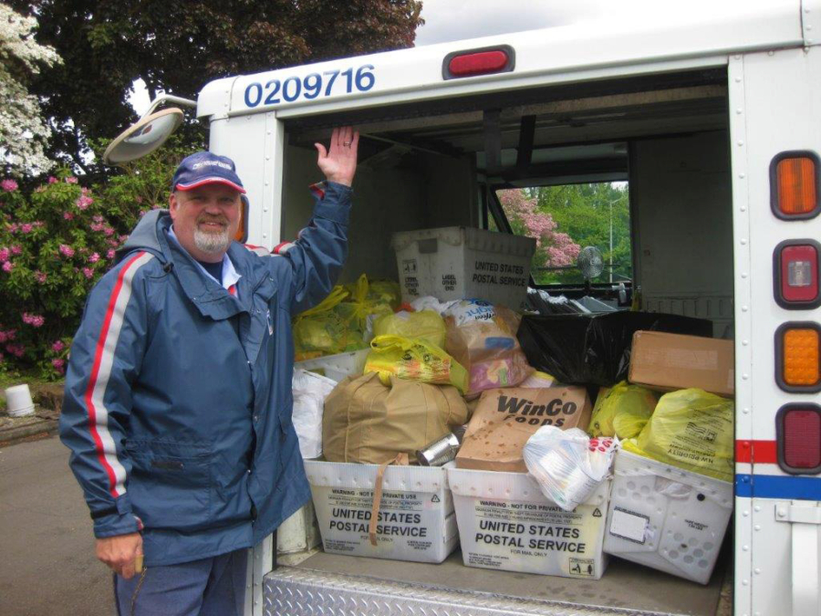 Vancouver letter carrier Larry Haas collects food donations during his mail route May 13 as part of the annual Stamp Out Hunger Food Drive.