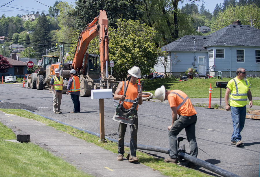 Amanda Cowan/The Columbian
Eric Levison, left in yellow vest, and Javier Moncada, second from left, of Otak, Inc., look on as crews begin construction on a year-long sewer expansion project, which will allow for growth north of Lacamas Lake in Camas.
