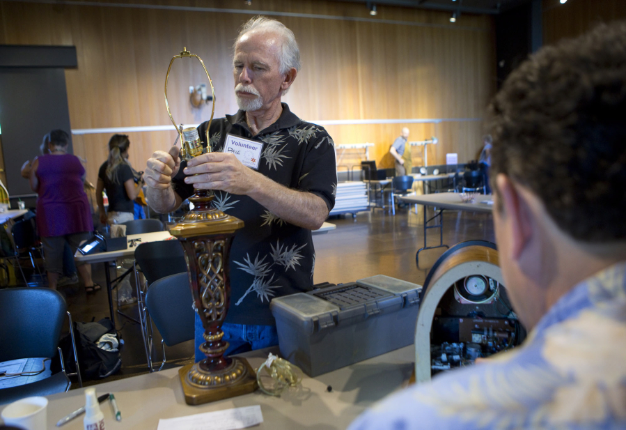 Volunteer Dave Meigs works on a lamp at the Repair Café Thursday at the Vancouver Community Library. Repair Café brings together volunteer fixers who repair items for free.