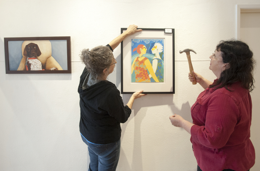 Painters Lynn Nadal, left, and Mary Alred hang their work at the North Bank Gallery in downtown Vancouver in 2015.