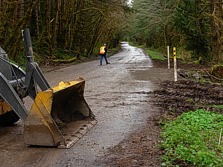 Road crews clear debris from the roadway in the Gifford Pinchot National Forest. An unusually high number of roads in the forest were blocked or damaged by heavy rain and snowstorms this winter and spring.