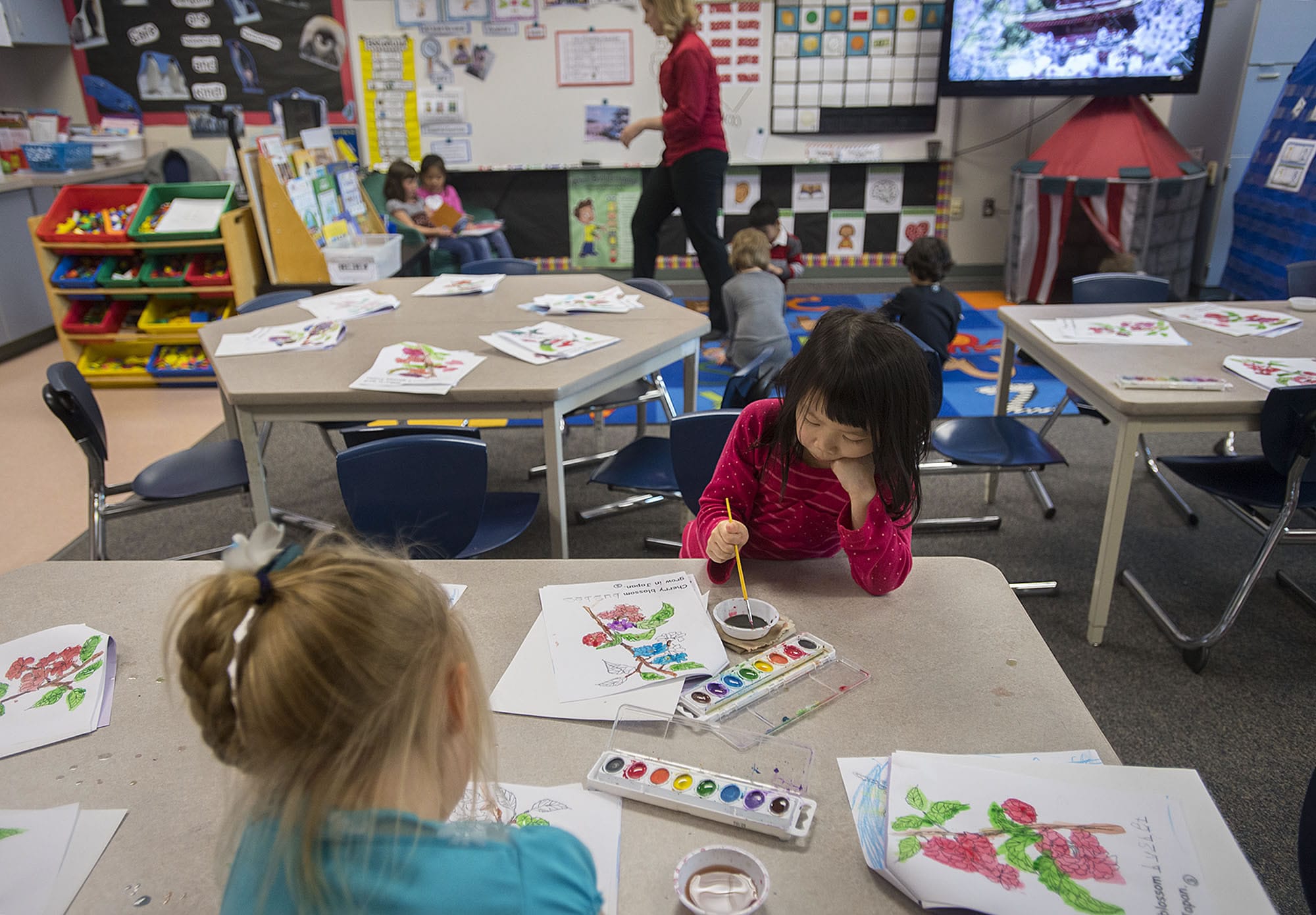 Kindergartner Grace Huynh, 5, facing in pink, joins classmates as they work on a painting during class at Prune Hill Elementary School on April 13.