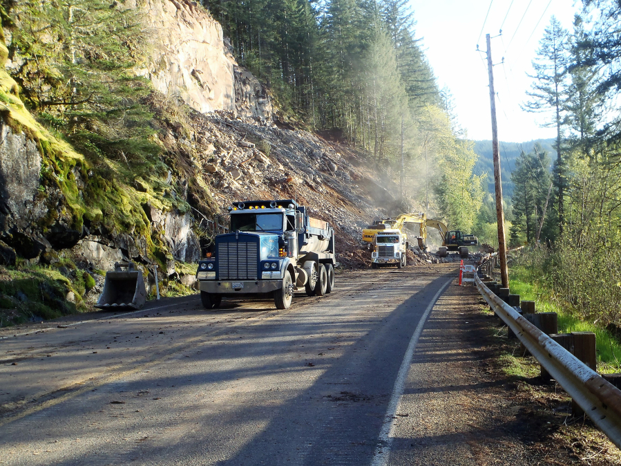 Crews working for the Washington State Department of Transportation clear loads of rocky debris off the roadway on state Highway 503.