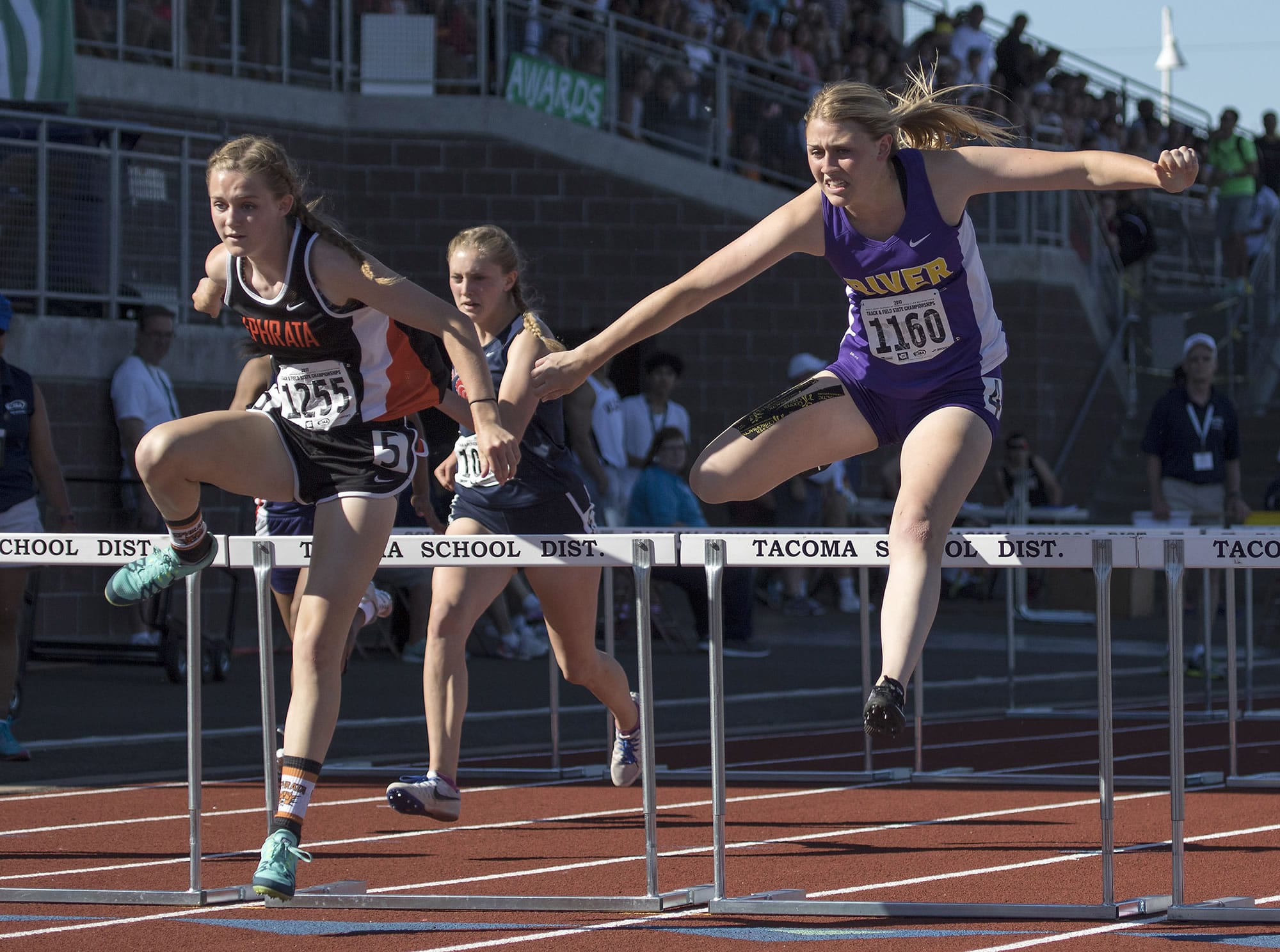 Columbia River's Ellie Walker, right, battles with Ephrata's McCall DeChenne, left, as they clear the final hurdle in the 2A Girls 100 Meter Hurdles event at the WA State Track and Field Meet Friday, May 26, 2017, in Tacoma, Wash. Walker had to settle for 2nd place finishing behind DeChenne.