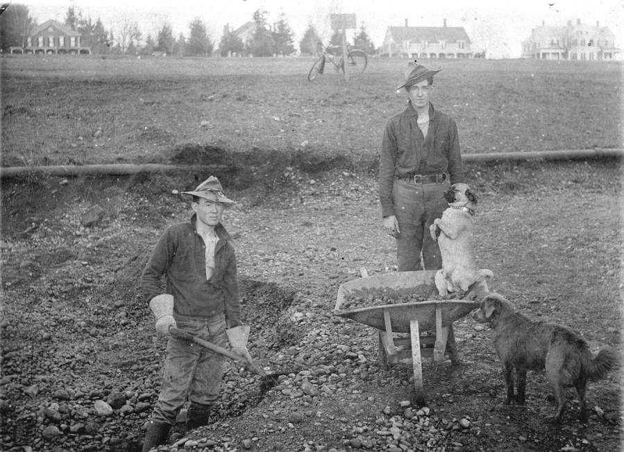 Soldiers at Vancouver Barracks on the job, enjoying the company of two dogs, in a photograph taken around 1903.