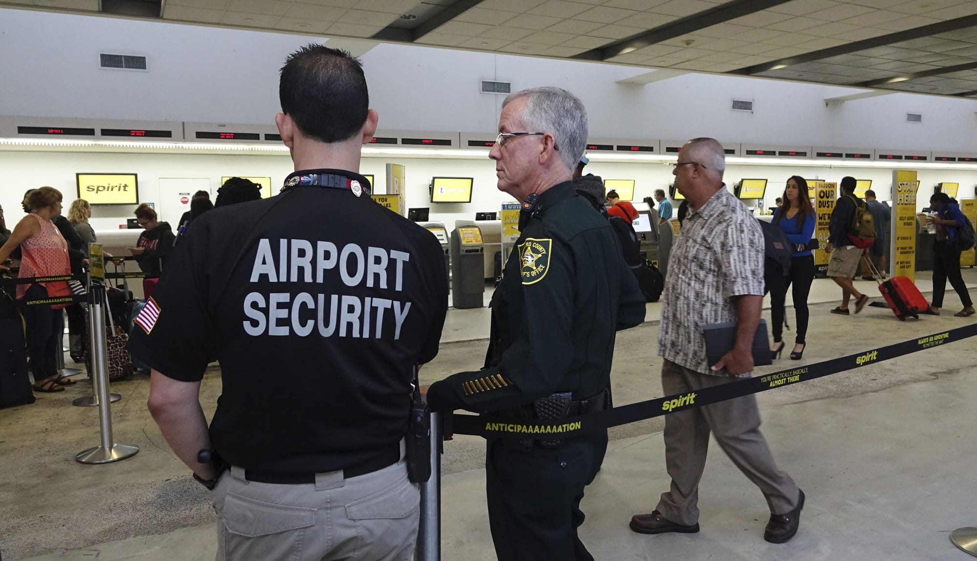 Airport Security and a Broward Sherriff's Deputy keep an eye on the line at Spirit Airlines, Tuesday, May 9, 2017, at the Fort Lauderdale-Hollywood International Airport in Fort Lauderdale, Fla. Skirmishes involving irate passengers broke out at the Florida airport Monday following the cancellation of multiple Spirit Airlines flights.
