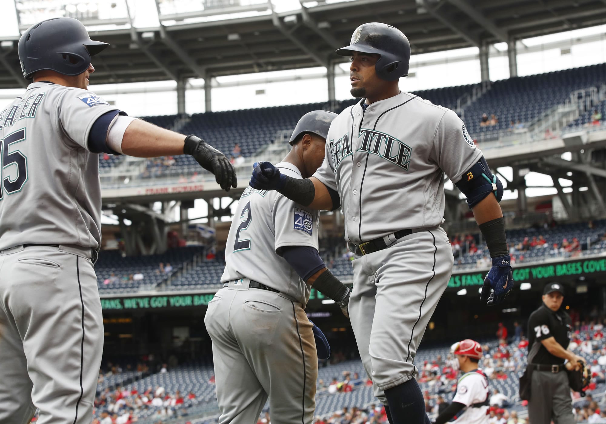 Seattle Mariners Nelson Cruz, right, celebrates with teammates, Kyle Seager, left, and Jean Segura (2) after hitting a three-run home run during the sixth inning of a baseball game against the Washington Nationals in Washington, Thursday, May 25, 2017. The Mariners won 4-2.