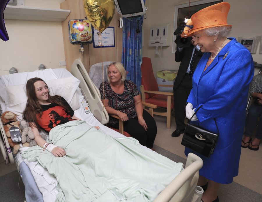 Britain’s Queen Elizabeth II. right, speaks Thursday to Millie Robson, 15, and her mother, Marie, as she visits the Royal Manchester Children’s Hospital in Manchester, England, to meet victims of the terror attack in the city earlier this week and to thank members of the staff who treated them.