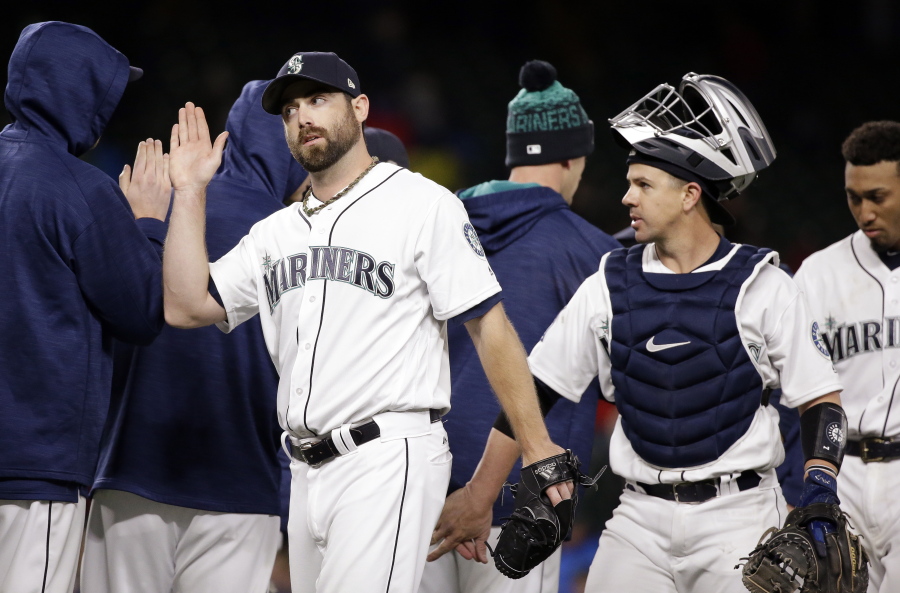 Seattle Mariners closing pitcher Tony Zych and catcher Tuffy Gosewisch share congratulations with teammates after the Mariners beat the Oakland Athletics in a baseball game Monday, May 15, 2017, in Seattle. The Mariners won 6-5.