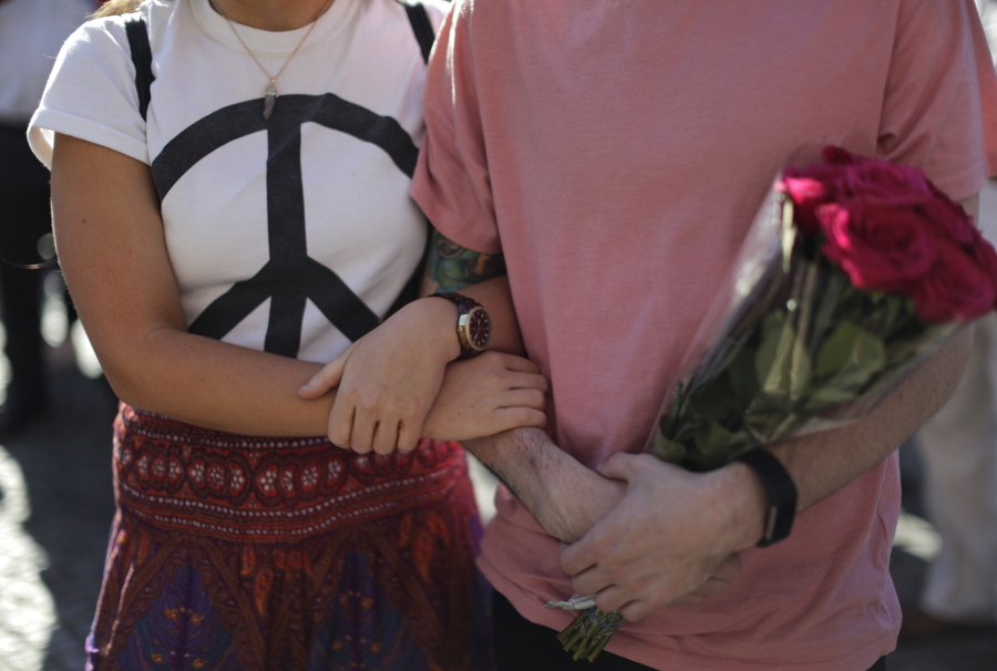 People link arms as they attend a vigil in Albert Square, Manchester, England on Tuesday, the day after the suicide attack at an Ariana Grande concert that left 22 people dead as it ended on Monday night.