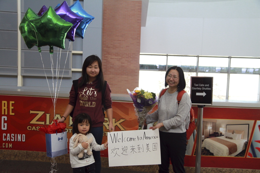 Chen Guiqiu, right, holds a &quot;Welcome to America&quot; sign with her daughters Xie Yajuan, 15, and Xie Yuchen, 4, after arriving at an airport in Texas. Chen whose husband, prominent rights lawyer Xie Yang, is held on charge of inciting subversion made a harrowing flight from China with her daughters chased by Chinese security agents across Southeast Asia.