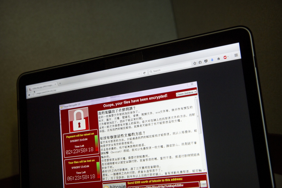 A screenshot of the warning screen from a purported ransomware attack, as captured by a computer user in Taiwan, is seen on laptop in Beijing, Saturday. Dozens of countries were hit with a huge cyberextortion attack Friday that locked up computers and held users’ files for ransom at a multitude of hospitals, companies and government agencies.