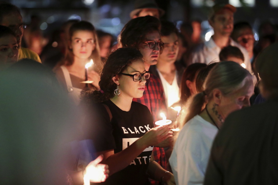 People in support of removal of confederate monuments hold candles during a counter-protest Sunday against those who on Saturday evening gathered to call on officials to halt the removal of a Gen. Robert E. Lee statue in Charlottesville, Va. Ryan M.