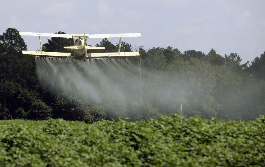 A crop duster sprays a field of crops in 2009 just outside Headland, Ala. The House passed a Republican-backed measure reversing an Environmental Protection Agency requirement that those spraying pesticides on or near rivers and lakes file for a permit.