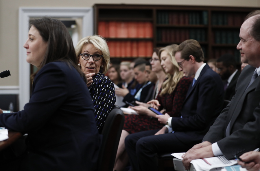 Education Secretary Betsy DeVos, second from left, joined by Education Department Budget Service Director Erica Navarro, left, turns to speak to people behind her before she testifies Wednesday on Capitol Hill in Washington, before the House Appropriations Labor, Health and Human Services, Education, and Related Agencies subcommittee hearing on the Education Department’s fiscal 2018 budget.