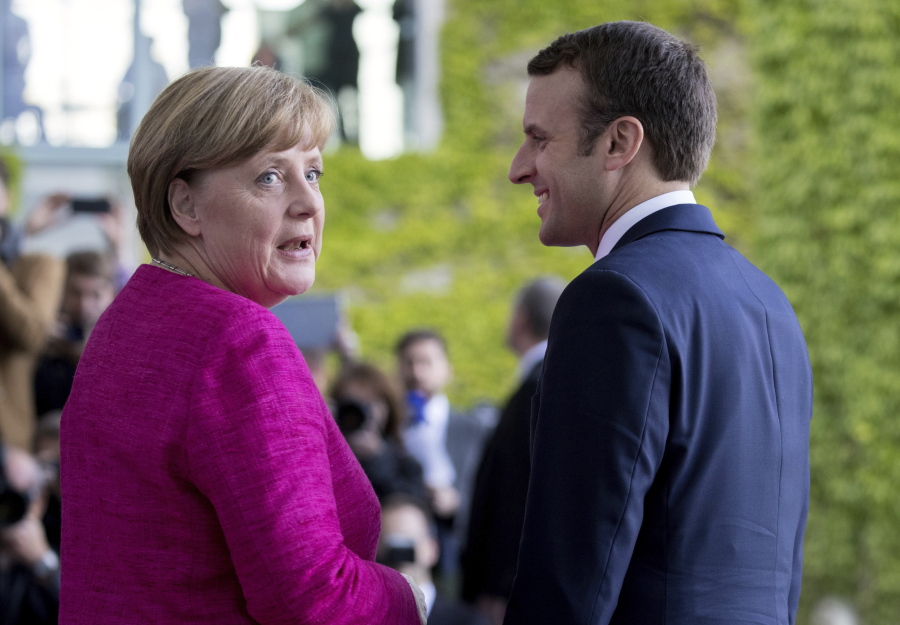 German Chancellor Angela Merkel, left, welcomes French President Emmanuel Macron in Berlin, Germany, on Monday.