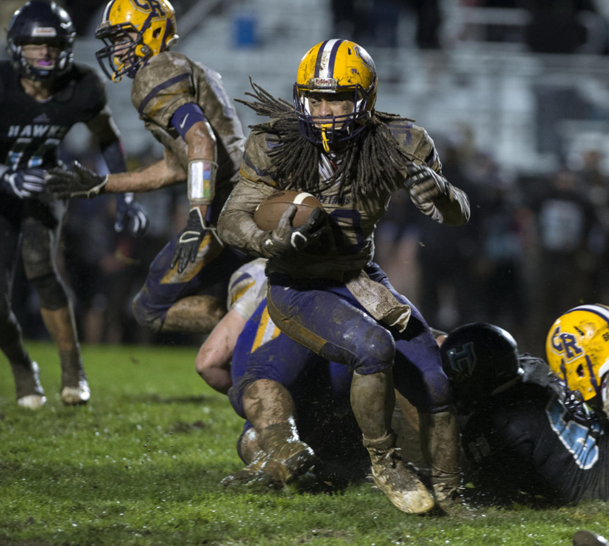 Columbia River's Hunter Pearson, with ball, makes his way through a muddy Hockinson High School field in October. Pearson died in an apparent drowning at Lacamas Lake on Saturday.