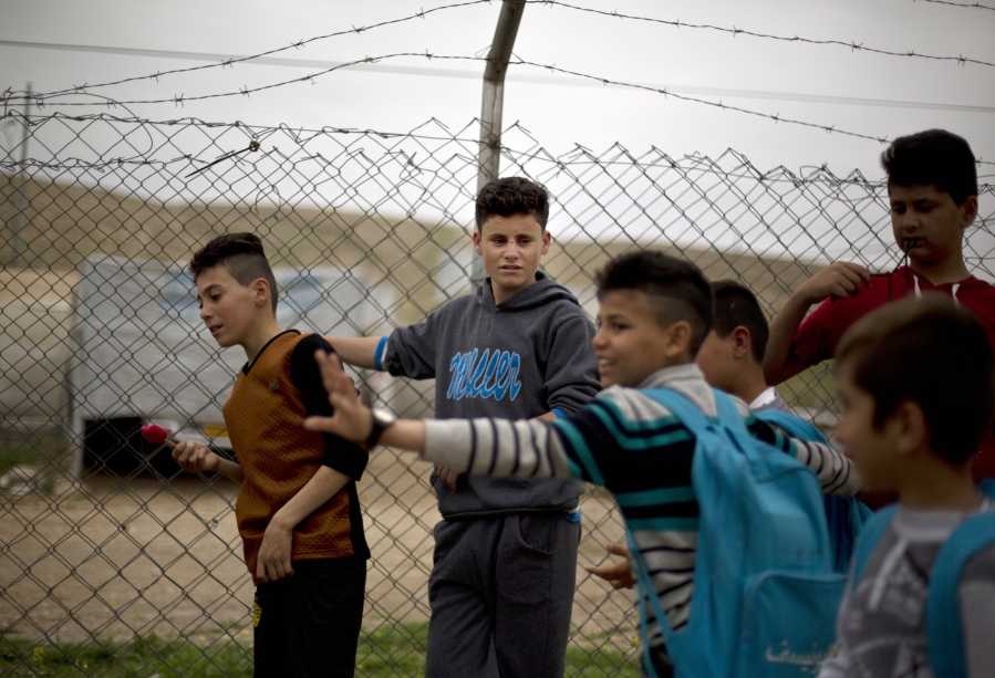 Ahmed Ameen Koro, 17, center, talks with other children after school in the Esyan Camp for internally displaced people in Dahuk, Iraq, on  April 13. Ahmed was among some 200 Yazidi boys captured by Islamic State militants and sent to a two-month training camp in Tal Afar. Their days began with early morning prayer and military training exercises, followed by study of the Quran. They learned to shoot Kalashnikovs and pistols. On a large screen, they watched videos on how to use a suicide belt, throw a grenade, or behead a person.
