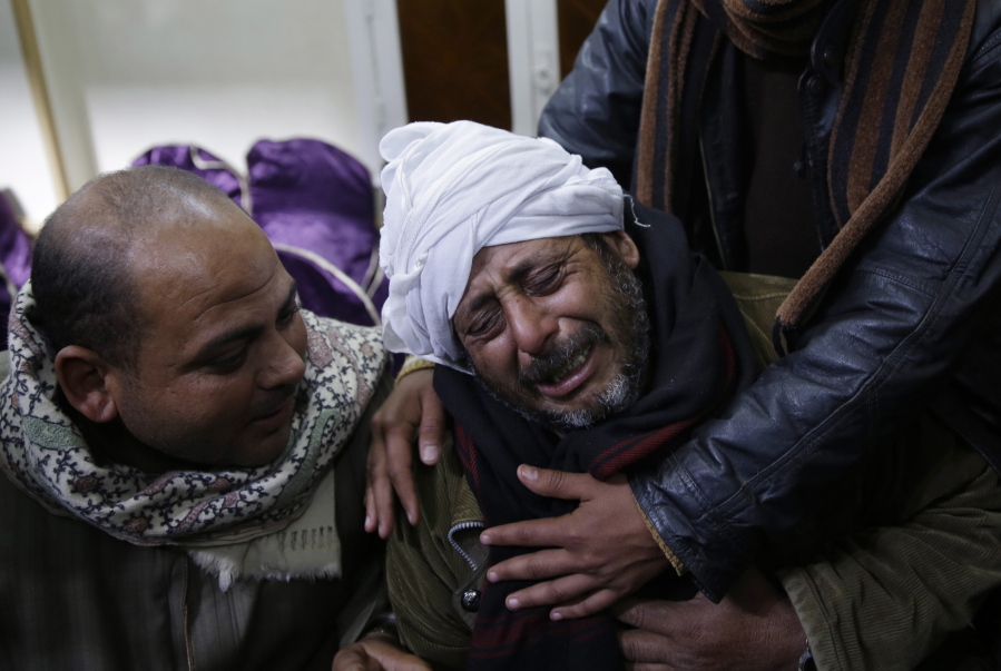 A man is comforted by others as he mourns over Egyptian Coptic Christians who were captured in Libya and killed by militants affiliated with the Islamic State group, outside of the Virgin Mary church in el-Aour, 135 miles south of Cairo, Egypt, on Feb. 16, 2015.